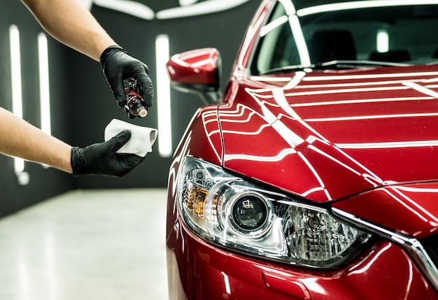 Team member cleaning a red car